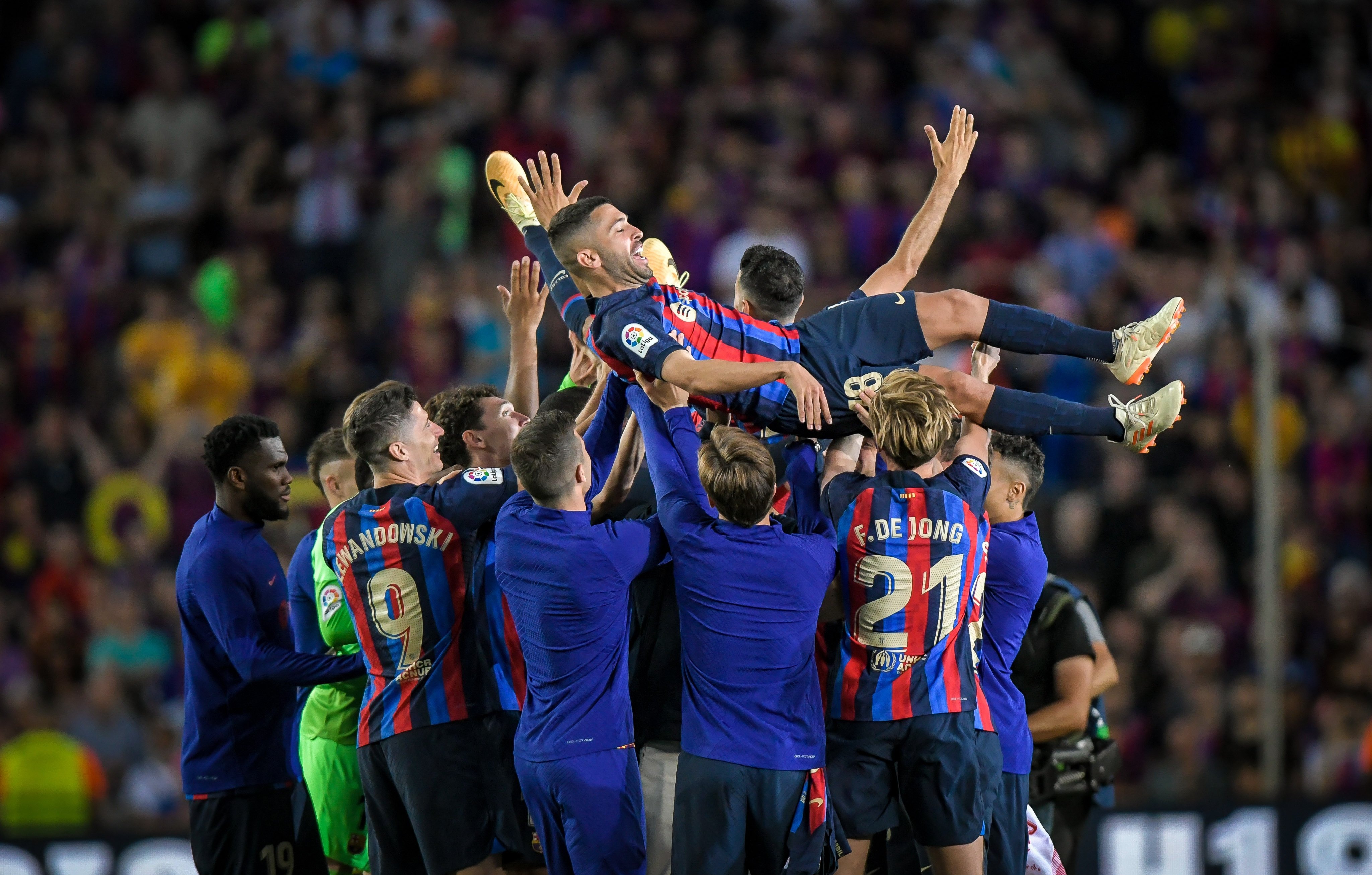 Alba is thrown in the air by his team-mates at the final whistle